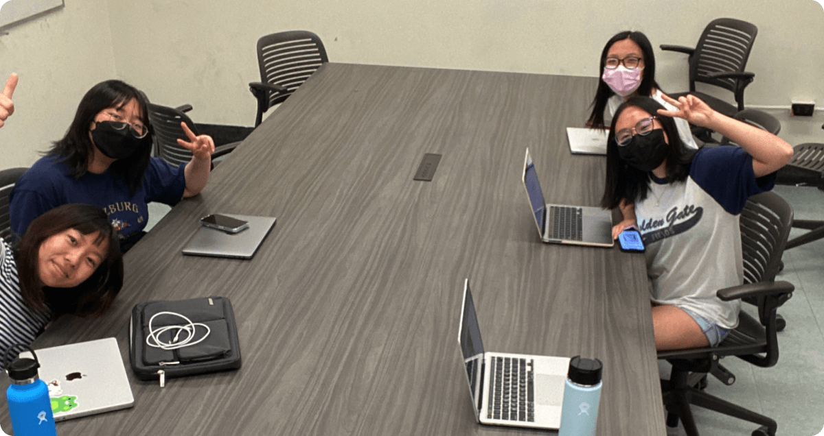 Group of four people surrounded at a meeting table.